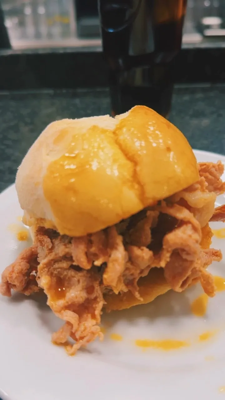 Uma bifana em pão, com o molho a escorrer